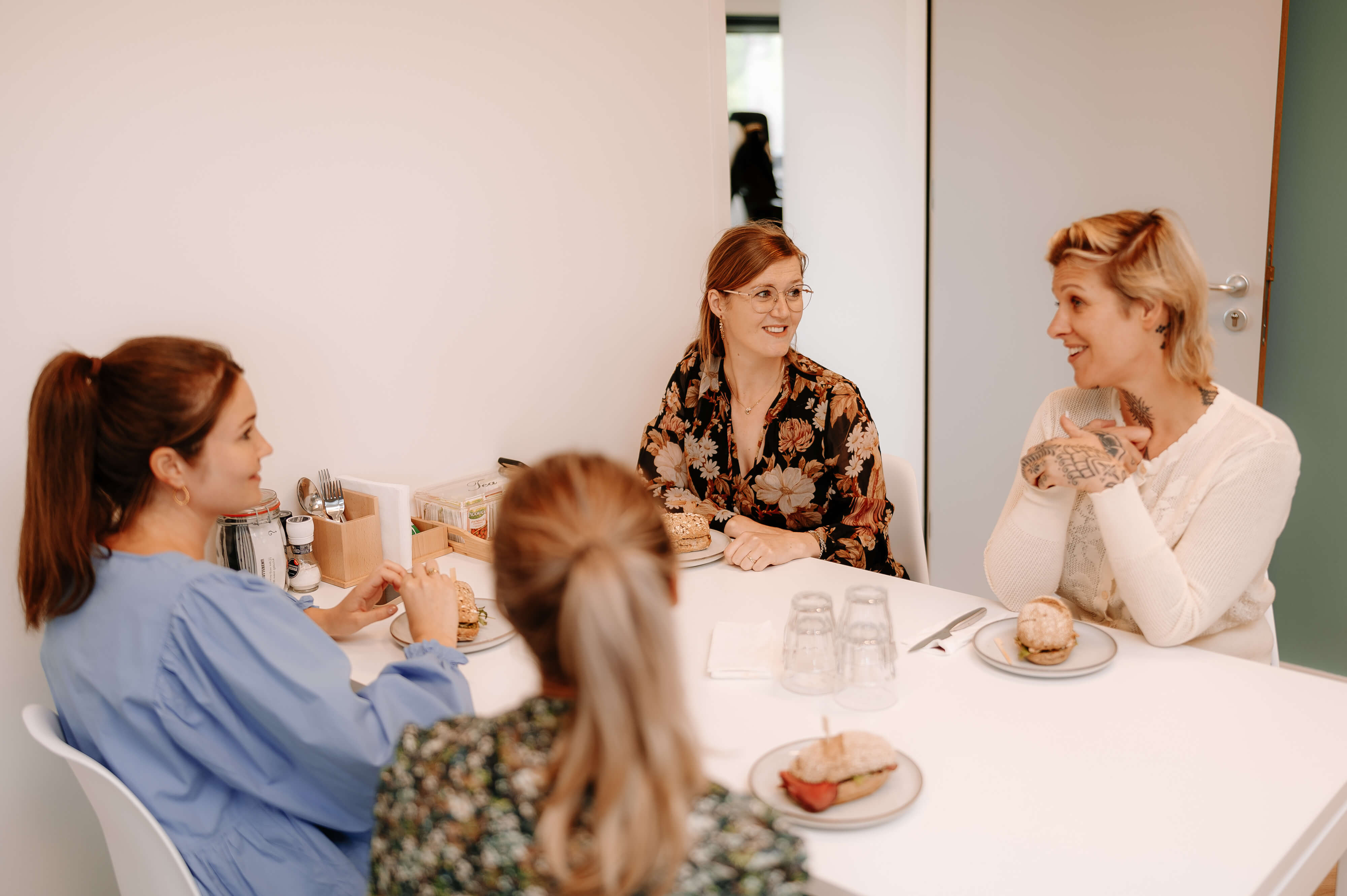 Four women talking over lunch at a table